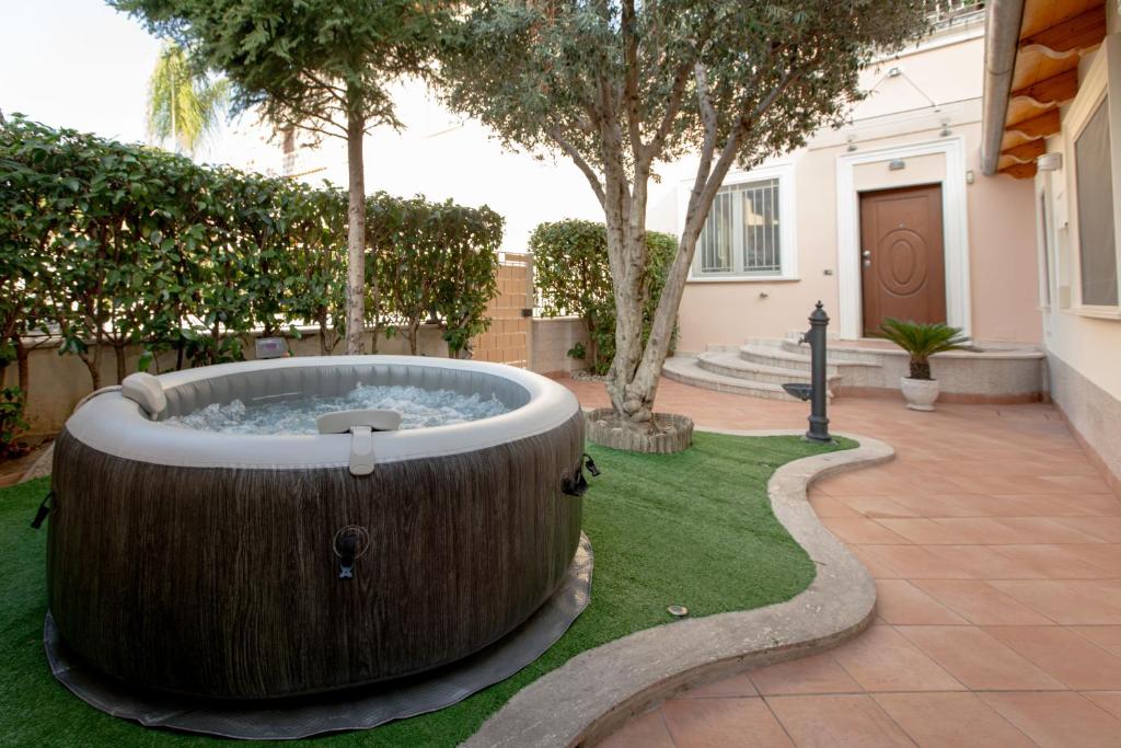 a large wooden tub in the middle of a yard at Favolosa residenza con jacuzzi in Santa Maria Capua Vetere