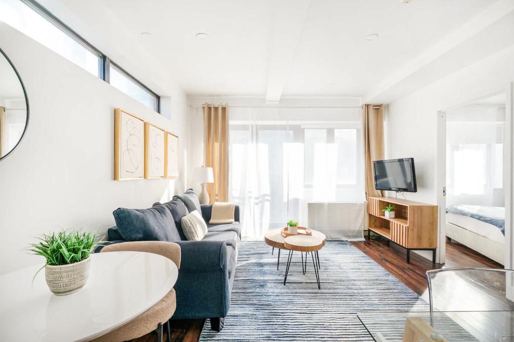 a living room with a couch and a tv at 809-5A Gorgeous New 1BR Heart of Midtown in New York