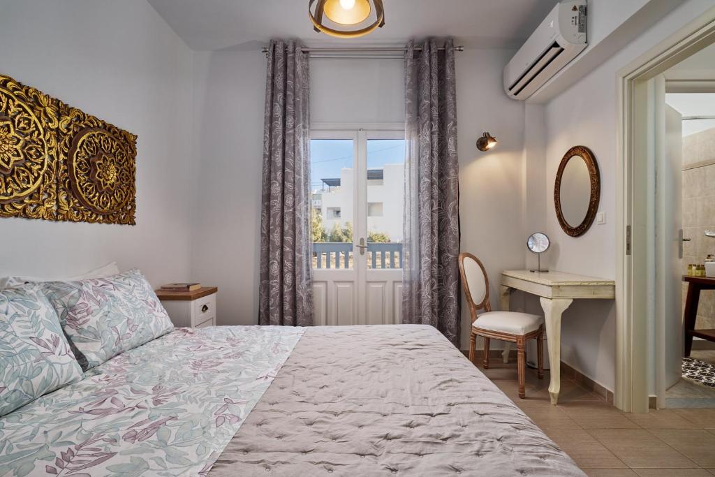 a bedroom with a bed and a desk and a window at Aroma Kastellia - Althea Homes in Amoopi