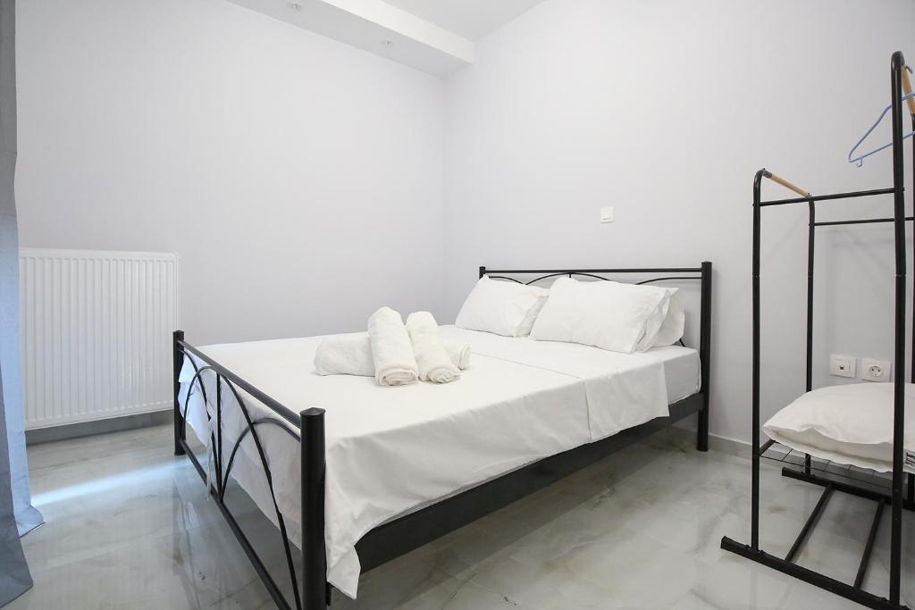 a bed with white sheets and white pillows on it at #C Ioannas Apartments in Thessaloniki