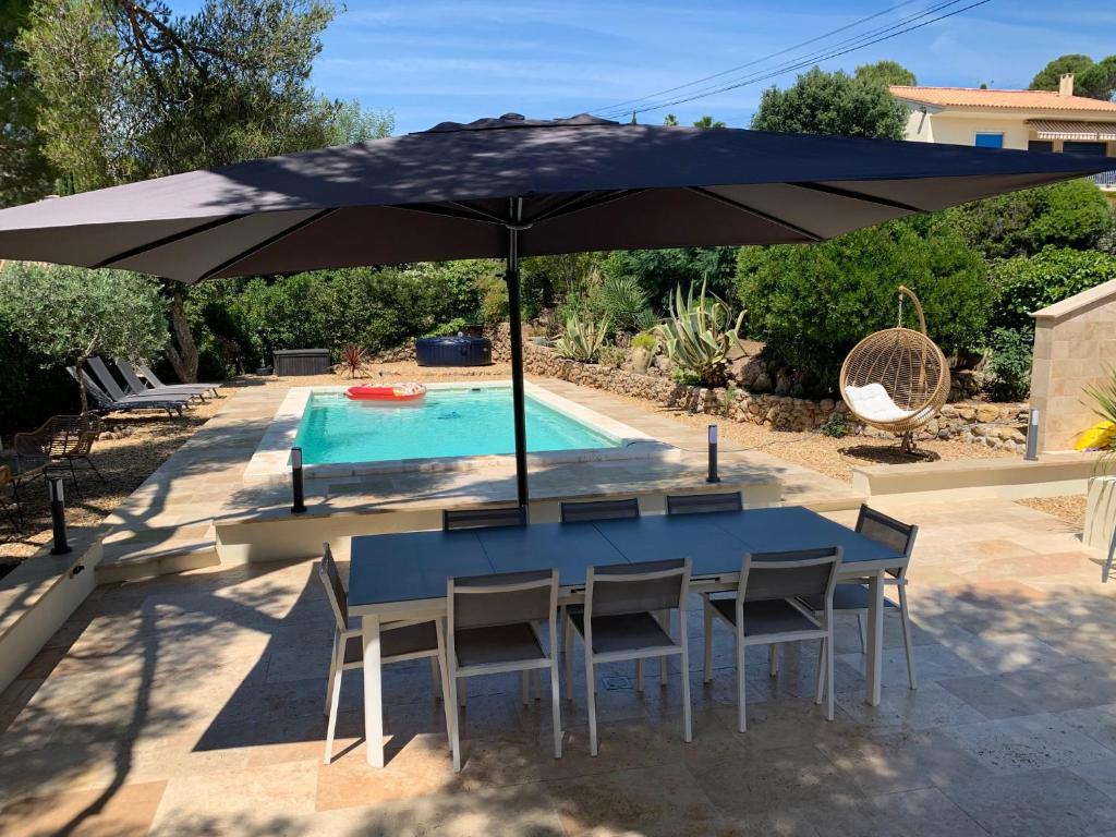 - une table bleue et des chaises sous un parasol à côté de la piscine dans l'établissement villa calme, à Saint-Aygulf