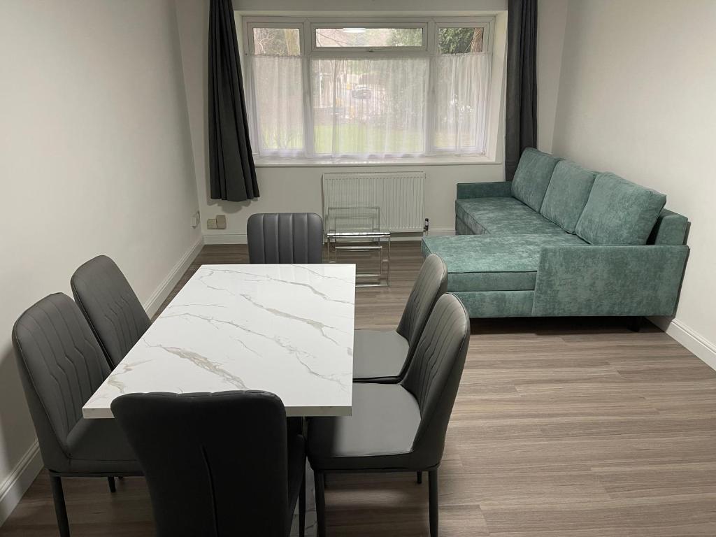 Una sala de estar con una mesa y sillas y un sofá. en Brighton Green Rose, en Brighton & Hove