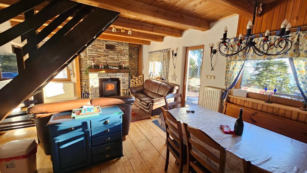 a living room with a table and a fireplace at Rogla - Chalet Mojca Pokrajculja in Zreče