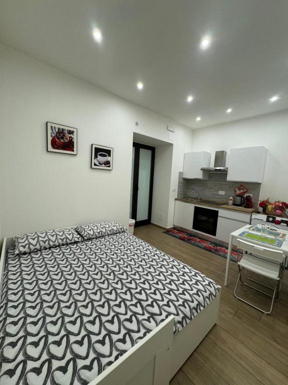 a bedroom with a large bed and a kitchen at Il Tulipano house in Catania