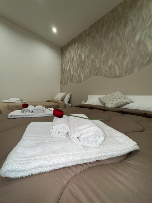 a bedroom with two beds with white towels on them at Il Tulipano house in Catania