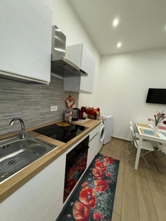 a kitchen with a sink and a kitchen rug at Il Tulipano house in Catania