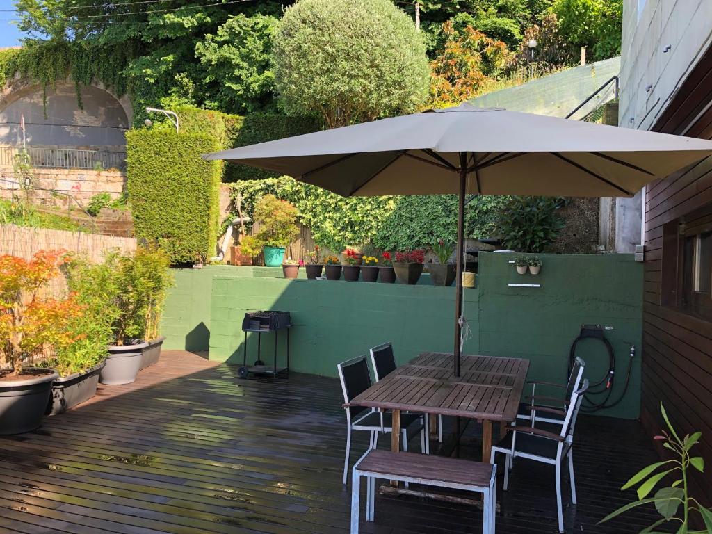 a table and chairs with an umbrella on a patio at Casa Grila in Pontevedra