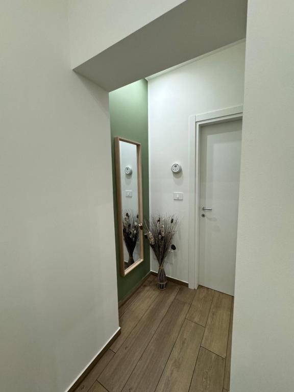 a hallway with a mirror and a vase of flowers at Il Tulipano house in Catania