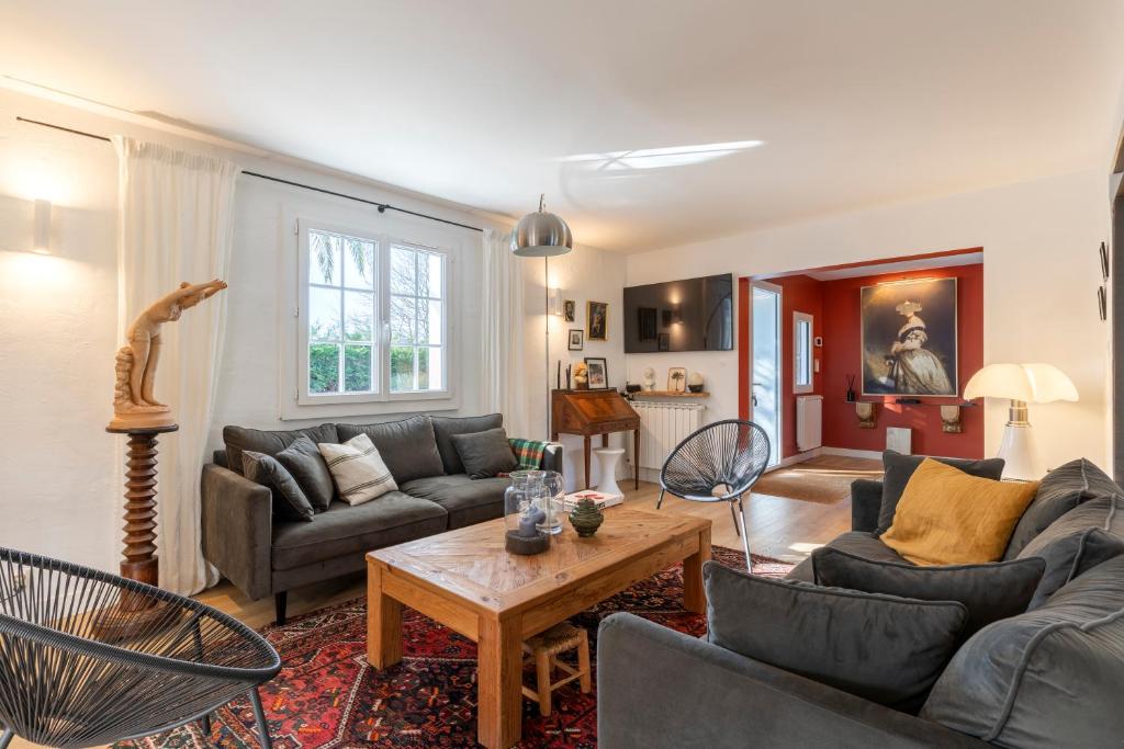 a living room with two couches and a table at Magnifique maison basque avec piscine 8 pers- Biarritz in Biarritz