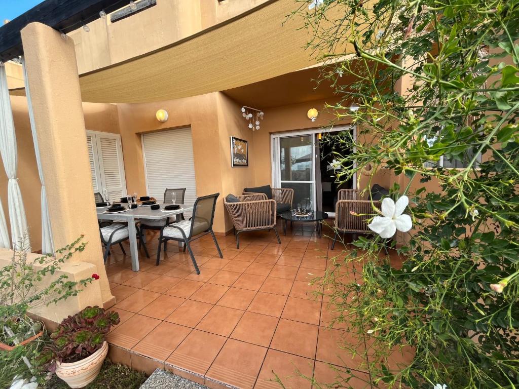 a patio with a table and chairs and a dining room at Villa Eric in Roldán