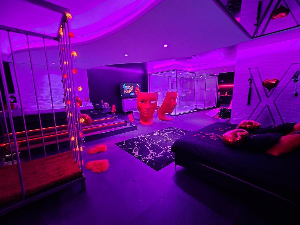 ein lila Zimmer mit einem Bett und einer Schaukel in der Unterkunft Les Secrets Rooms in Hagondange