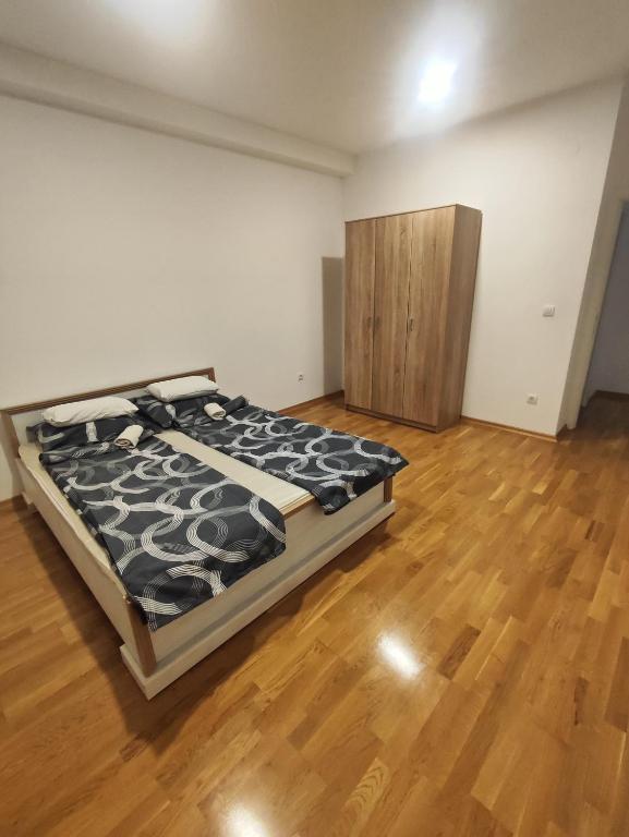 una camera con letto e pavimento in legno di Lux apartman Ub a Ub