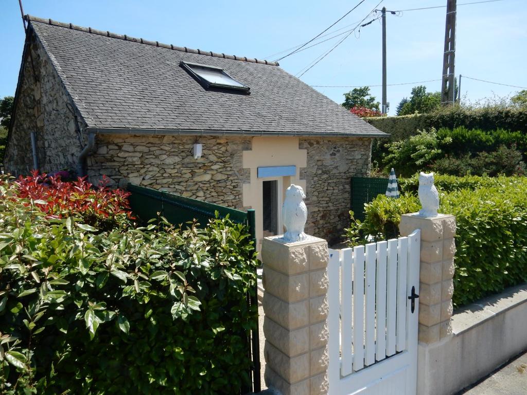 une petite maison en pierre avec une clôture blanche dans l'établissement Béniguet, à Paimpol