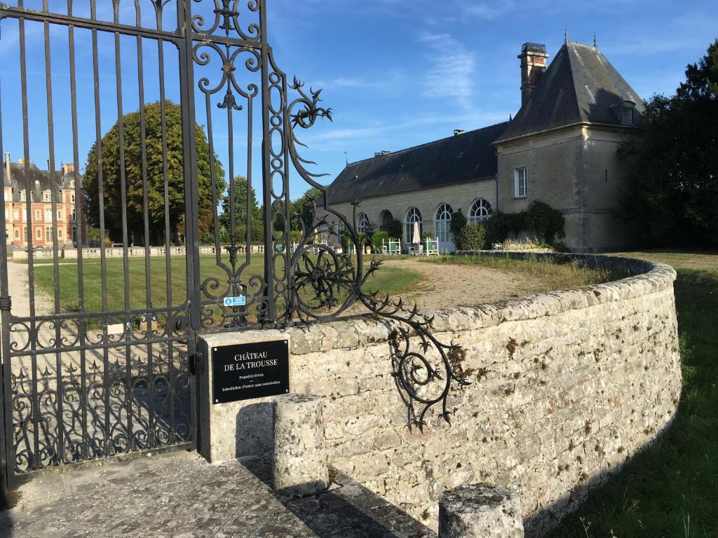 une porte avec un panneau devant un bâtiment dans l'établissement The Orangery apartment, Chateau de la Trousse, à Ocquerre