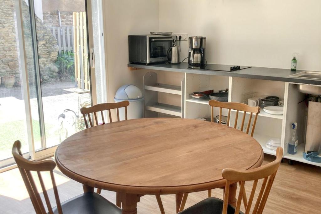 - une cuisine avec une table et des chaises en bois dans l'établissement Appartement charmant à Quiberon, 45 m², vue sur jardin, à Quiberon