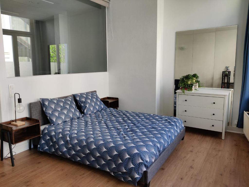 a bedroom with a bed and a dresser and a mirror at Nice Flat Grand Place in Brussels