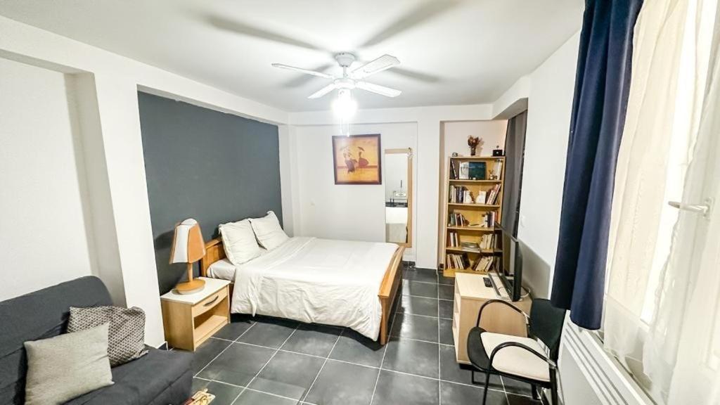 une petite chambre avec un lit et un canapé dans l'établissement Cosy appartement proche Paris - aéroport CDG - RER D à 8 min à pied, à Goussainville
