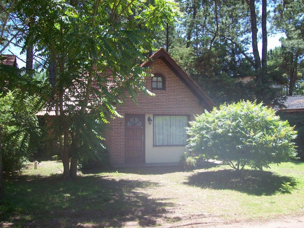 ein kleines Backsteinhaus mit einer roten Tür in der Unterkunft La casita de Loly in Carilo