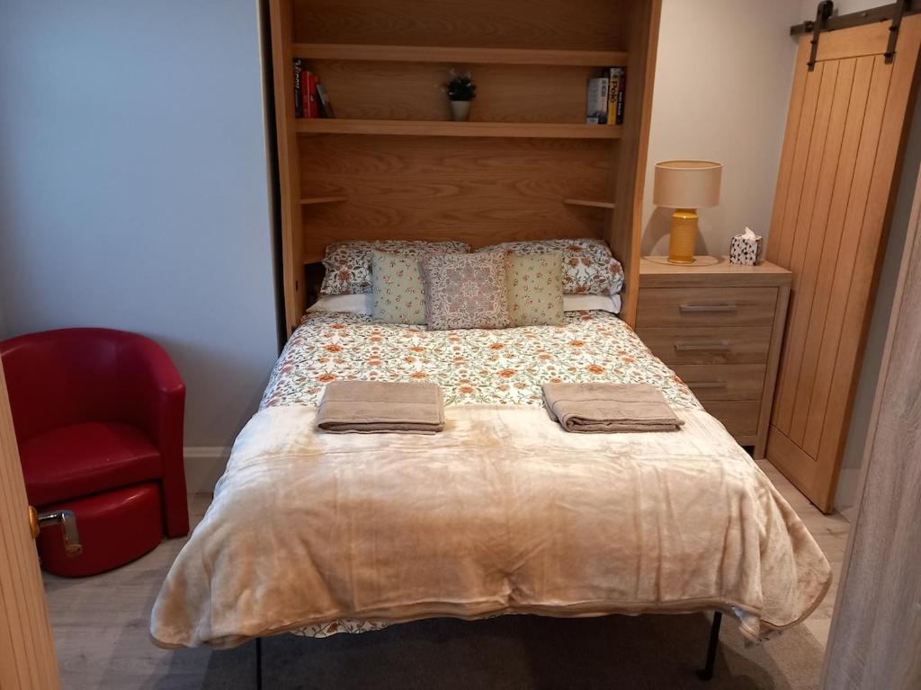 a bedroom with a bed and a red chair at Self Check in Flat 1 Jubilee Guest House in Bognor Regis