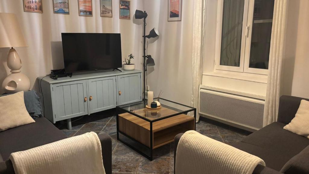 a living room with a flat screen tv on a cabinet at Le Quatorze in Bollène