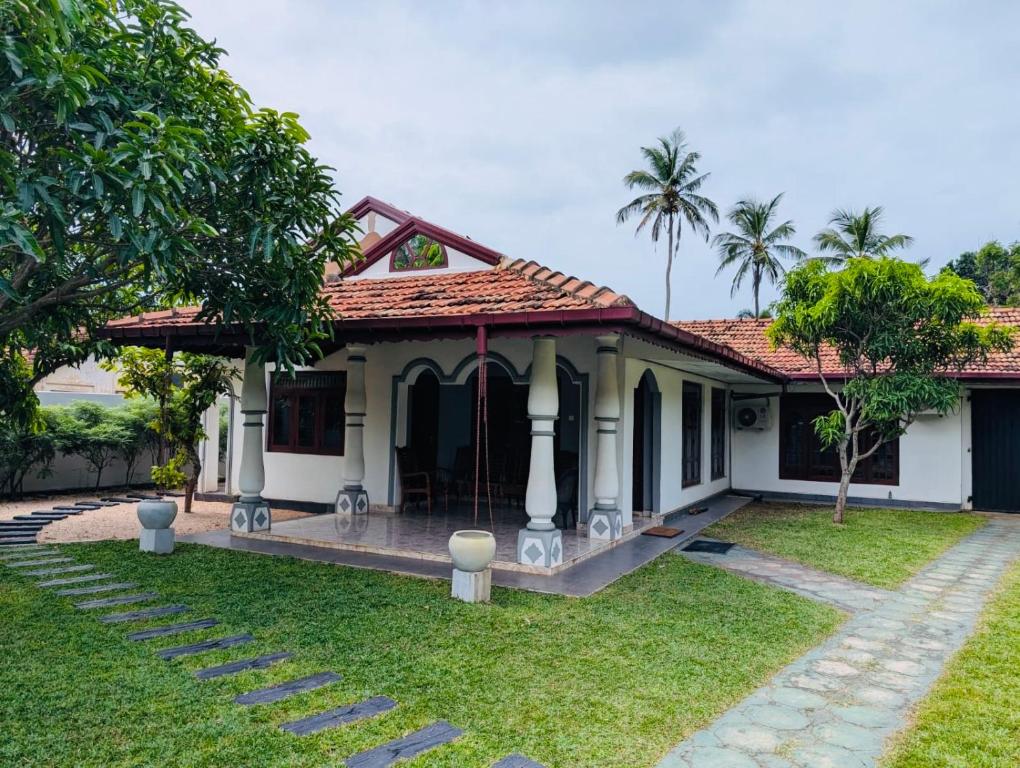 a small white house with a red roof at Dona's Villa Coastal House in Pamunugama in Negombo