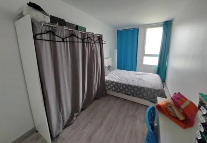 une petite chambre avec un lit et une fenêtre dans l'établissement Chambre avec sdd privee, à Élancourt