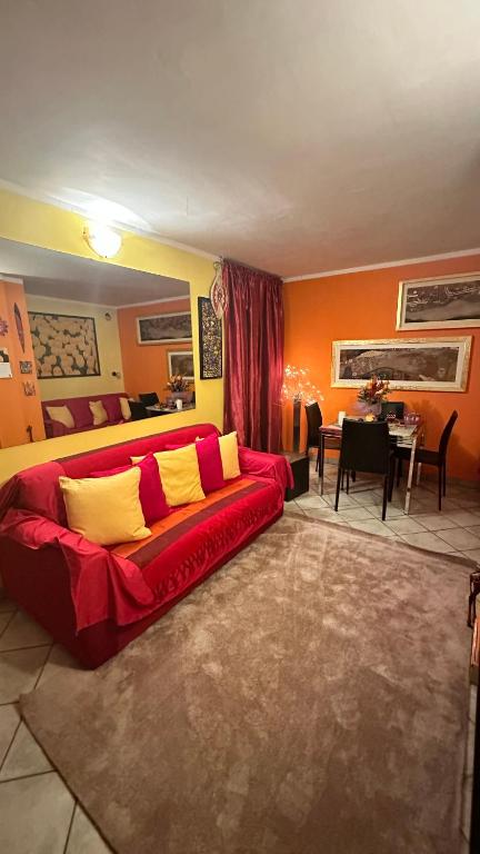 a living room with a red couch and a dining room at Casa di Cricci in Sestriere