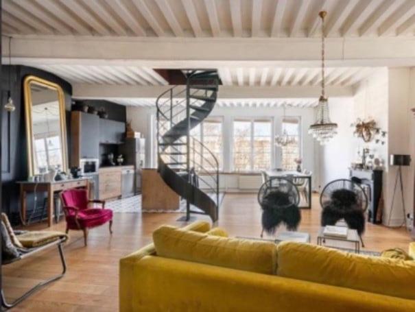 un salon avec un canapé jaune et un escalier en colimaçon dans l'établissement Le Prestige Vieux Lyon, Duplex Vue sur la Saône, à Lyon
