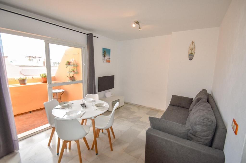 a living room with a couch and a table at Ático centro Tarifa in Tarifa