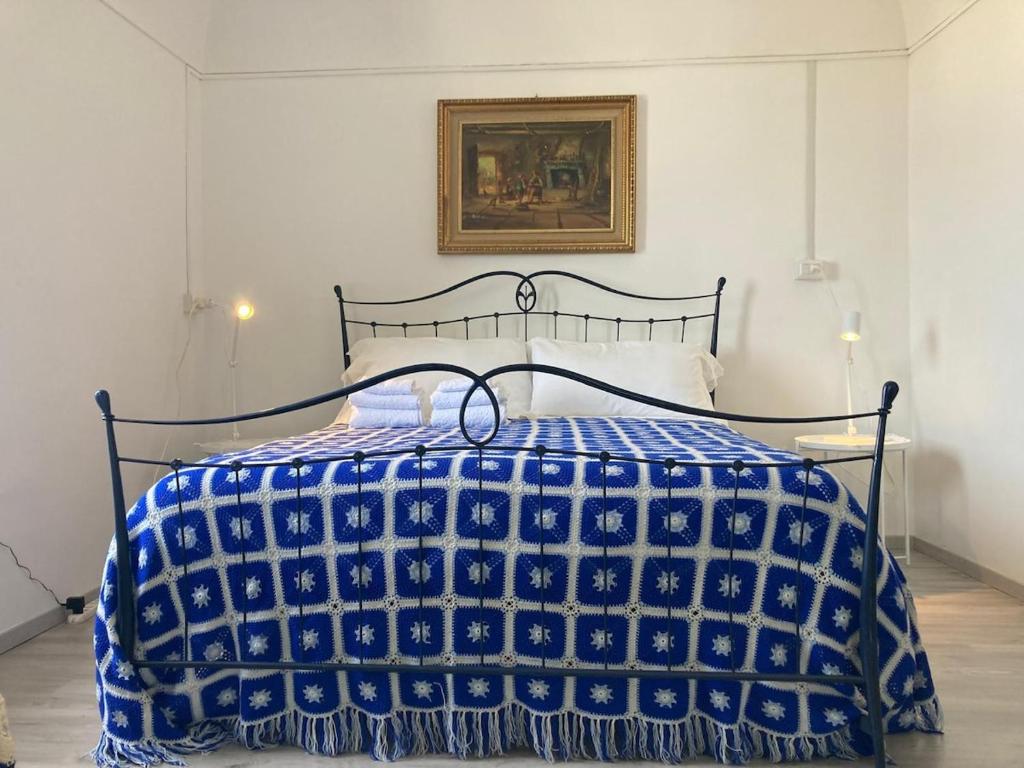 a bedroom with a bed with a blue and white comforter at Appartamentino nel castello in Miglianico