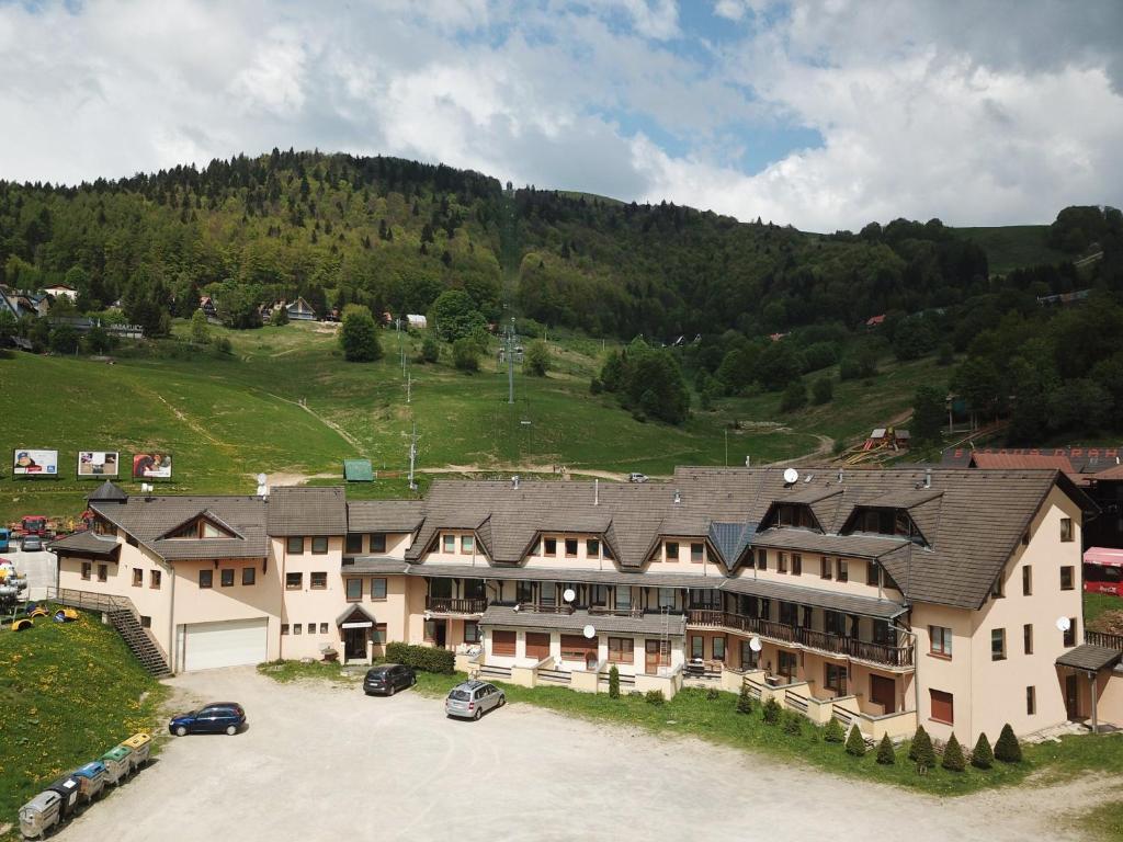 a large building with cars parked in a parking lot at Donovaly apartmán 33 in Donovaly