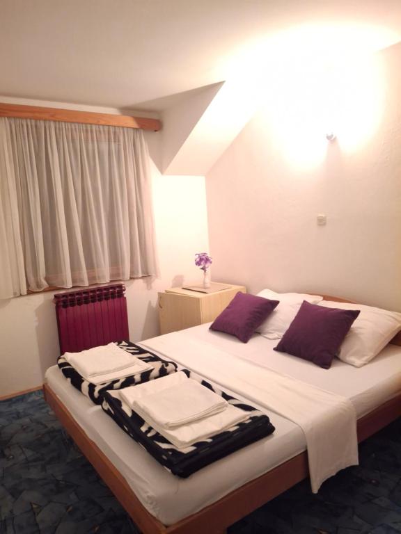 a bedroom with a large bed with towels on it at Restoran Prenociste As in Trnovo