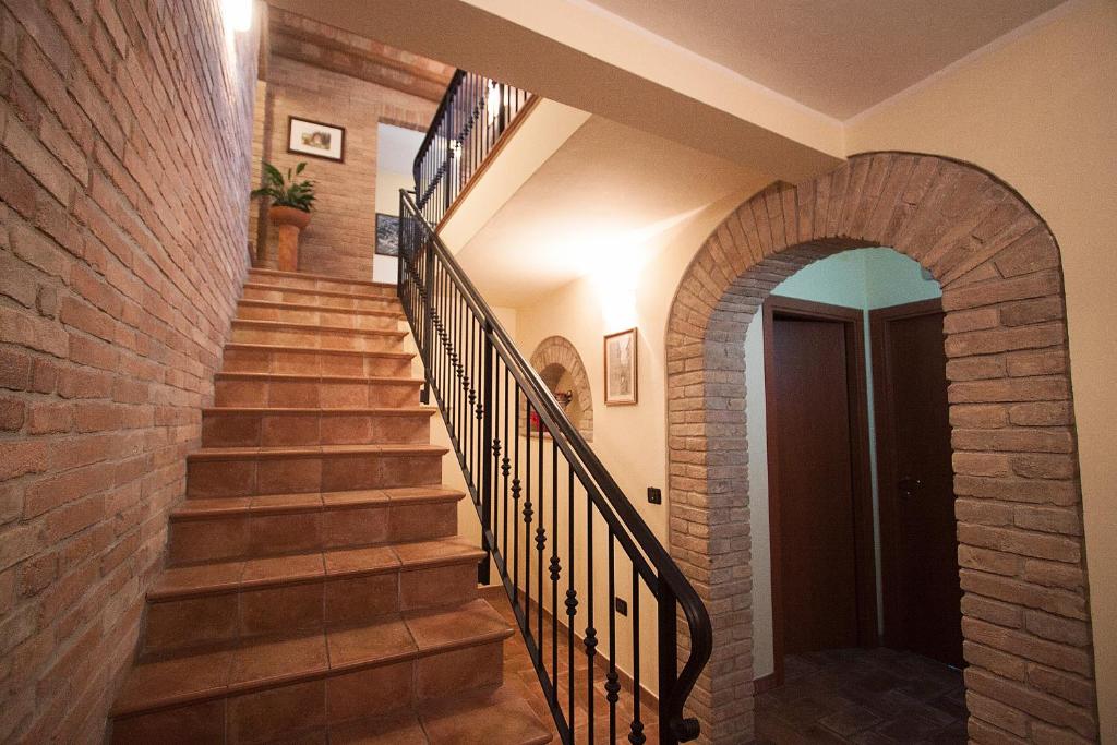 una escalera con una pared de ladrillo y una escalera de ladrillo en Camere Santucci, en Asís