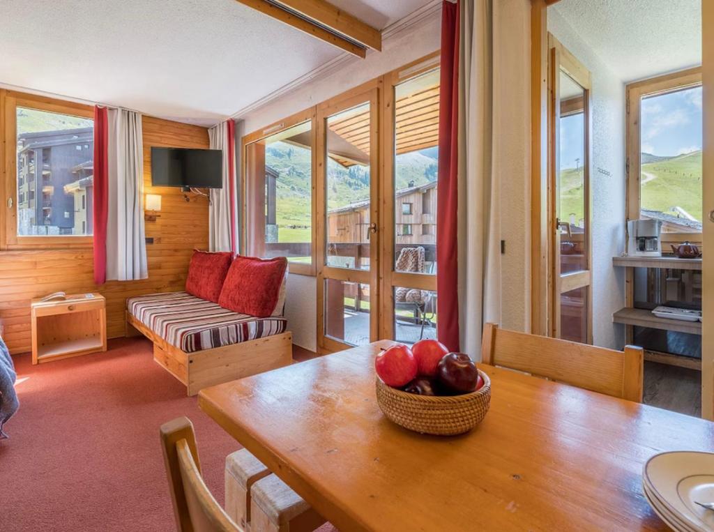un salon avec une table avec un bol de fruits dessus dans l'établissement Les Terrasses Blanches - Appartement Belle Plagne - 4 personnes - Exposition plein Sud - Sur pistes, à La Plagne Tarentaise