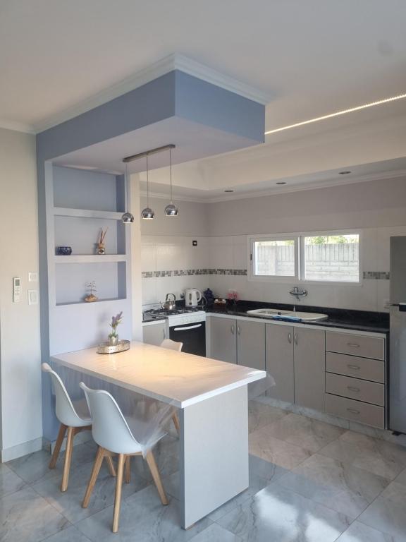 a kitchen with a table and some chairs in it at Tu descanso en Coronel Suarez in Coronel Suárez