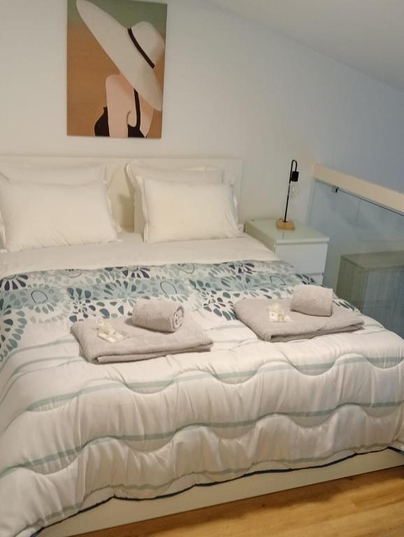 a white bed with towels on top of it at Guest House CR5 in Porto