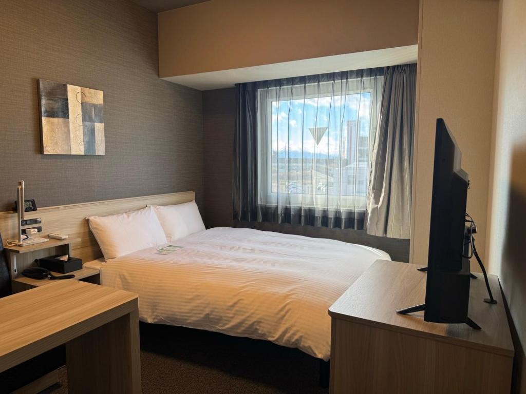 Postel nebo postele na pokoji v ubytování Hotel Route Inn Ginan -Kokudo 21 Gou-