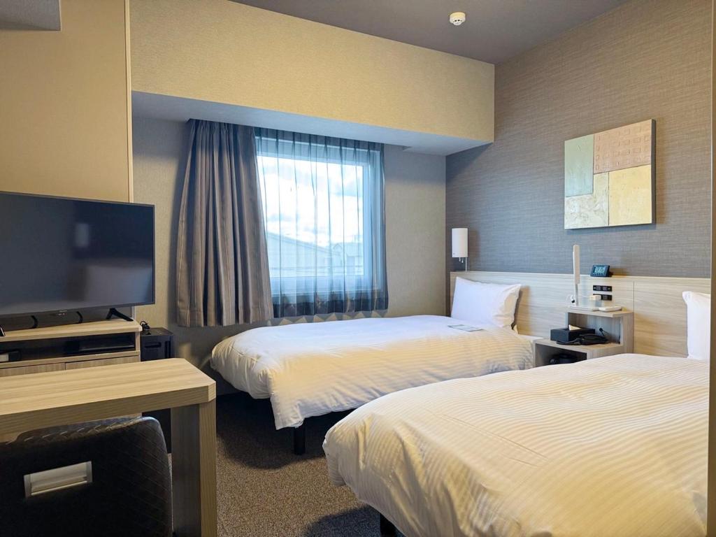 Postel nebo postele na pokoji v ubytování Hotel Route Inn Ginan -Kokudo 21 Gou-