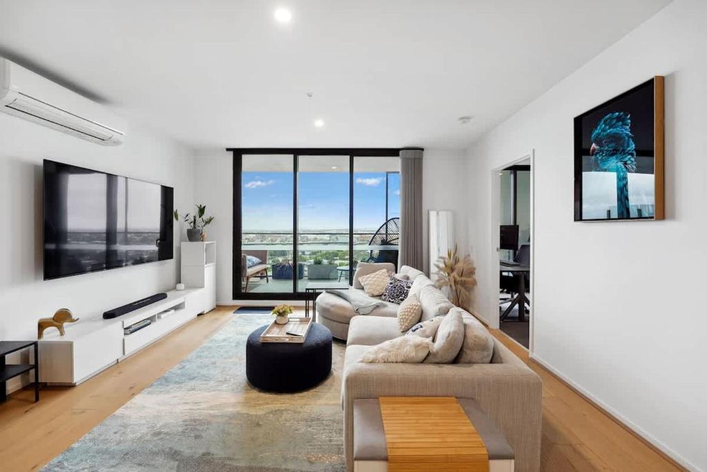 a living room with two couches and a large window at Riverina - Ultimate Footscray Getaway with parking in Melbourne