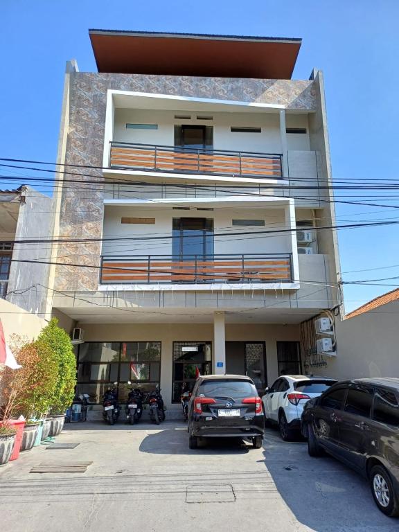 a building with cars parked in front of it at Phoenix Living in Surabaya