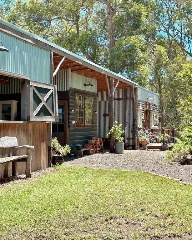 a house with a porch with a bench in front of it at The Milking Shed in Kurrajong