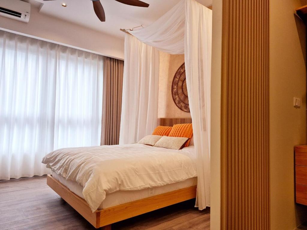 a bedroom with a canopy bed with white curtains at Agile Pavillion TRX Luxury Suited Kuala Lumpur Good View in Kuala Lumpur