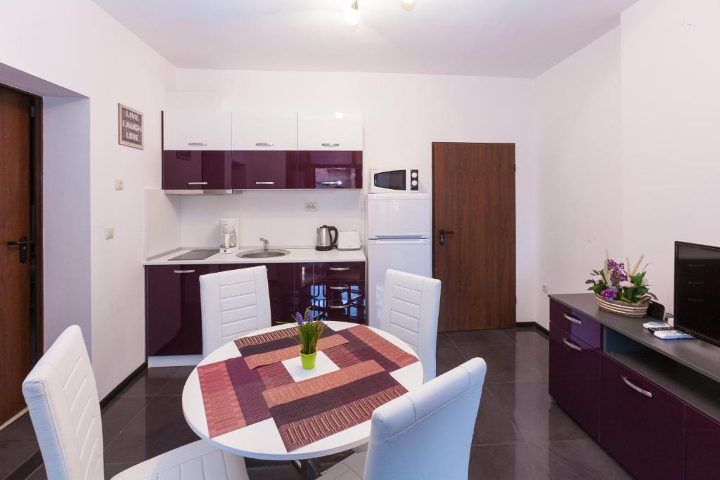 ブルガスにあるCentral Beach GUEST ROOMSのテーブルと椅子のあるキッチンとダイニングルーム