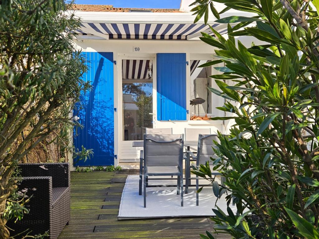 a patio with chairs and a blue door at Maisonnette proche plage et forêt, parking, wifi - FR-1-476-230 in La Faute-sur-Mer