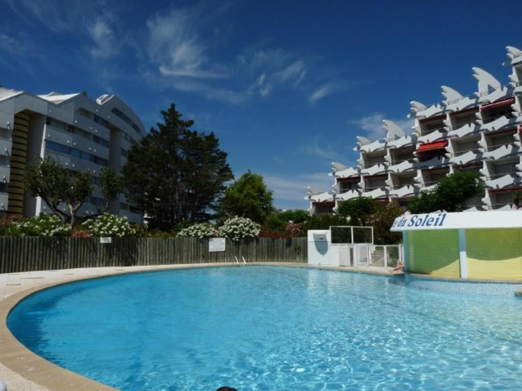 une grande piscine en face de deux immeubles d'appartements dans l'établissement 2 pièces avec piscine, proche plage, parking, 4 pers - FR-1-328-271, à La Grande Motte