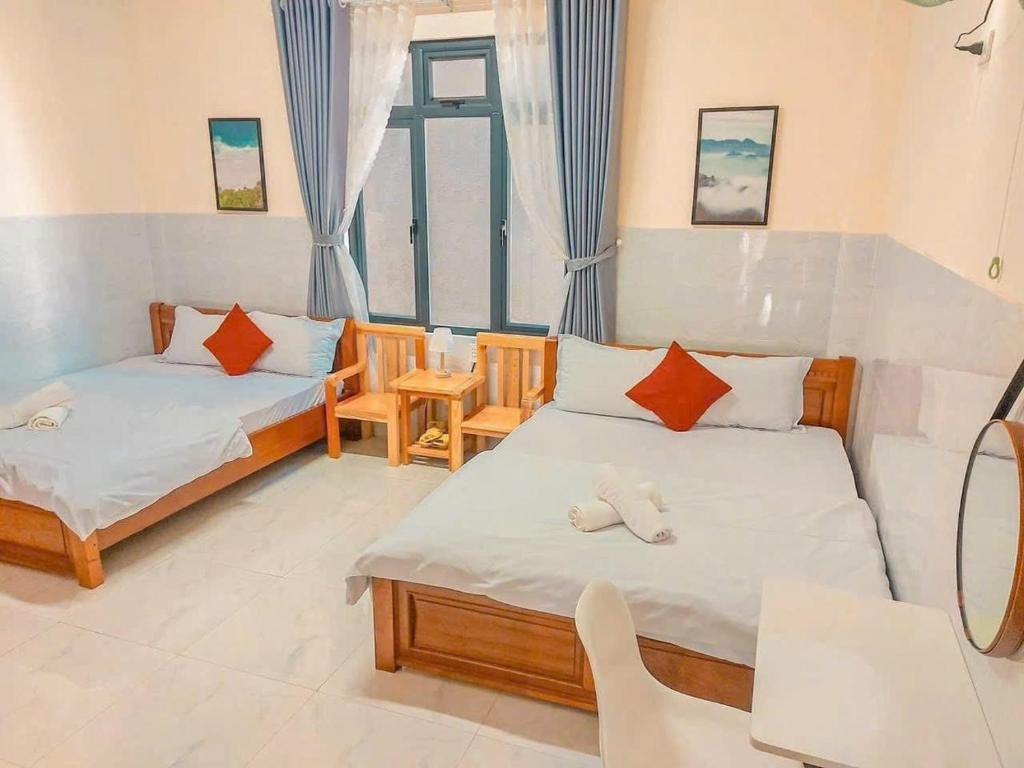 a bedroom with two beds and a window at Nhà Nâu Homestay DL- by BAY LUXURY in Da Lat