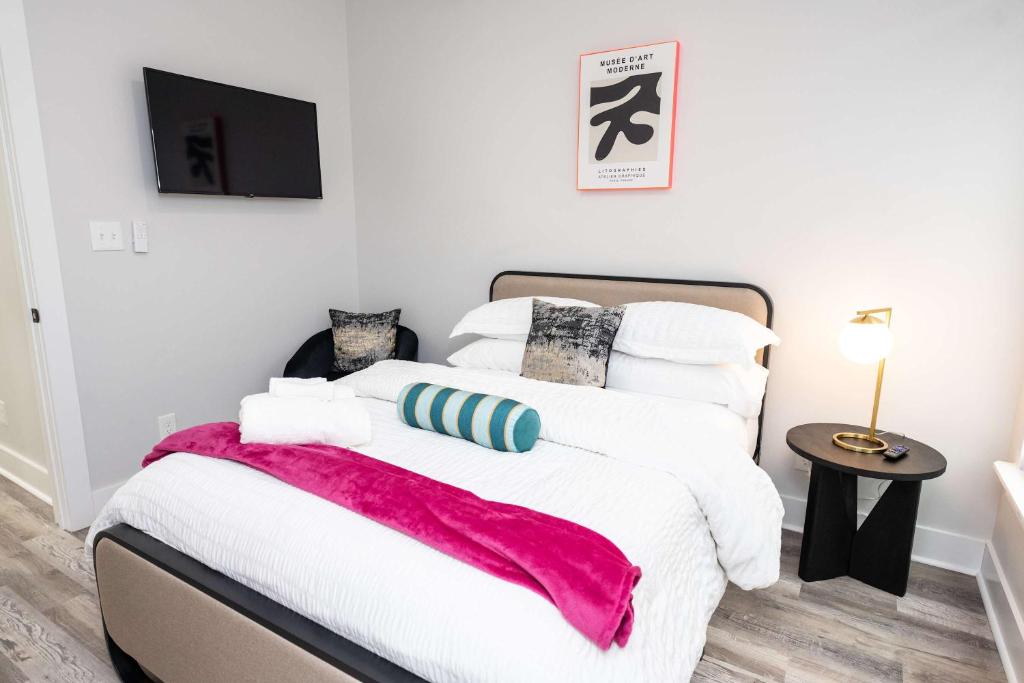 a bedroom with a white bed with a red blanket at Mid City Magic 5 in New Orleans