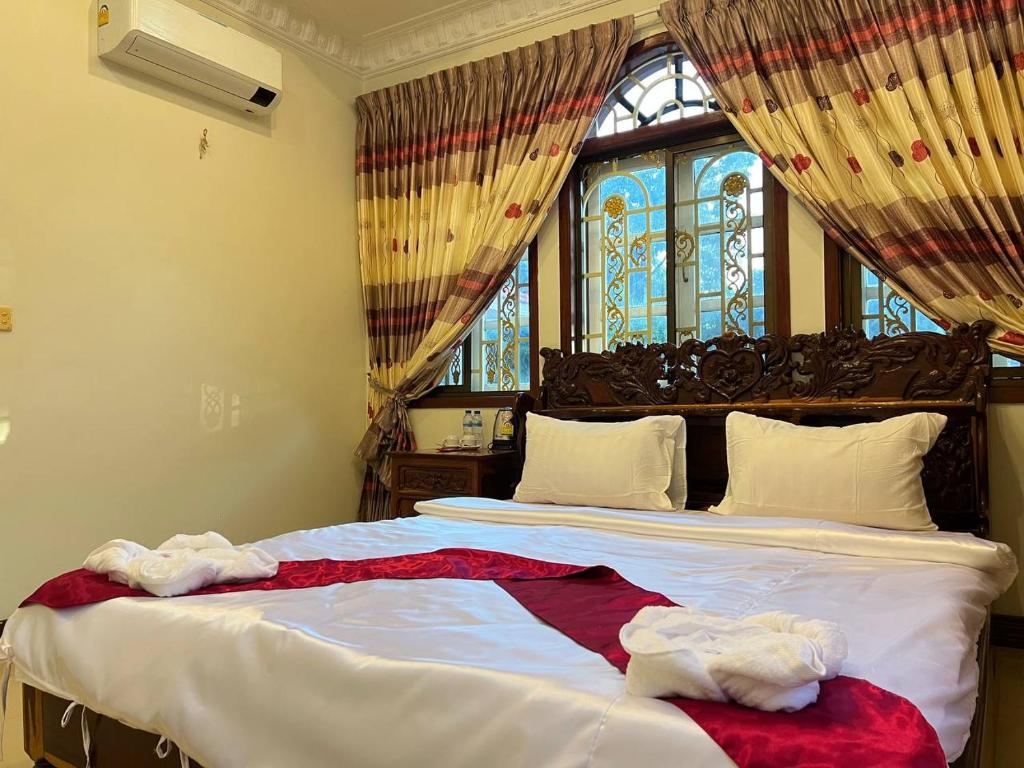 a bedroom with a large bed with a window at Lotus Blanc Homestay Village in Battambang