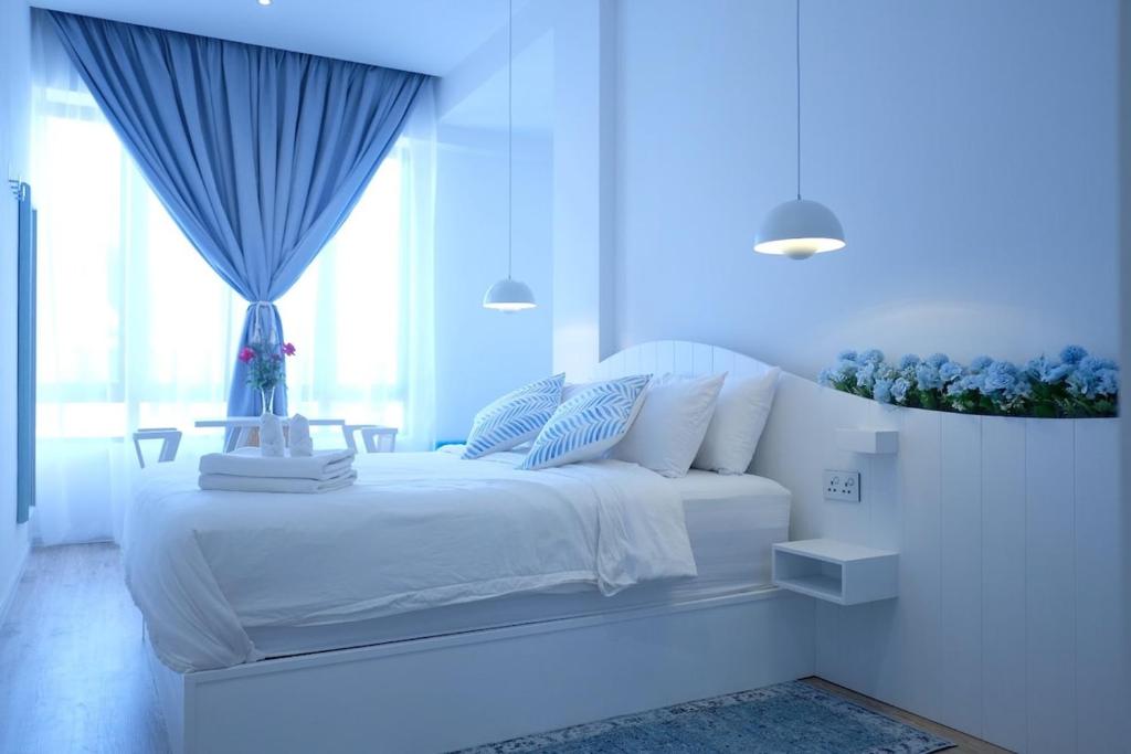 a white bedroom with a white bed with a window at Tung Kidcove Centrum Cameron in Brinchang