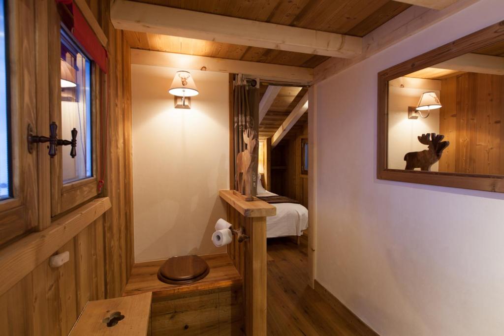 a hallway with a mirror and a bed in a room at Cabane entre terre et ciel in Saint-Nicolas-la-Chapelle